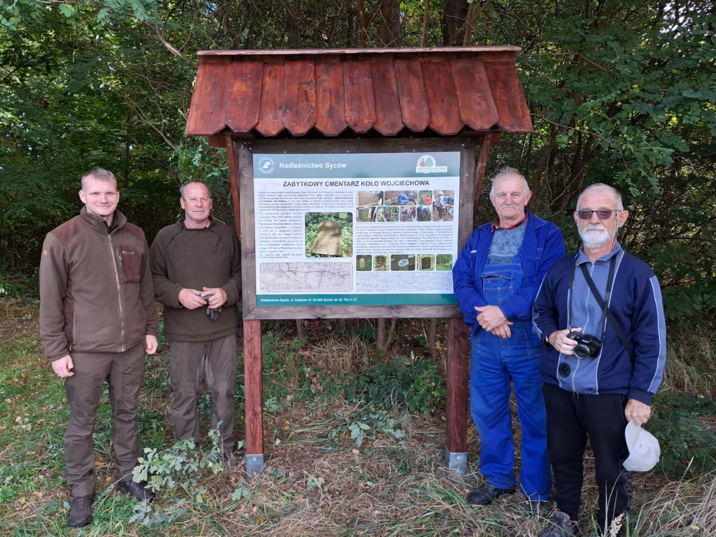 Fot. Tablica w leśnictwie Widawa. Na zdjęciu pracownicy Arboretum Leśnego, podleśniczy leśnictwa Widawa oraz Pan Edmund Goś podczas montażu tablic. Fot. M. Zapart. Autor opracowania tablicy - M. Zapart. 